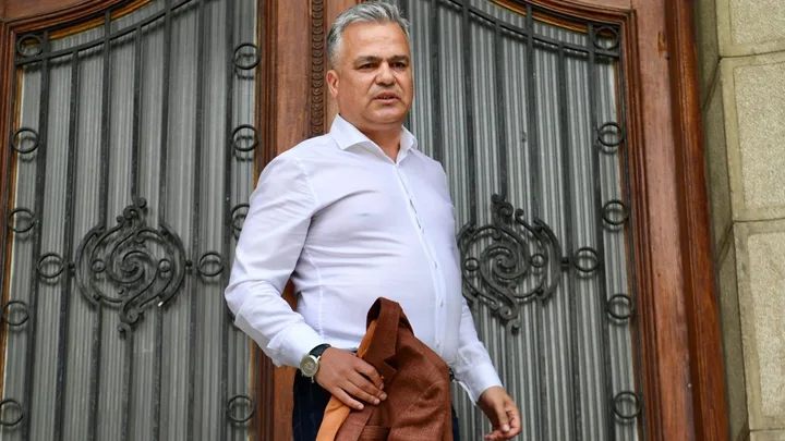 Adrian Veștea la ieșirea dintr-o clădire oficială, purtând o jachetă.