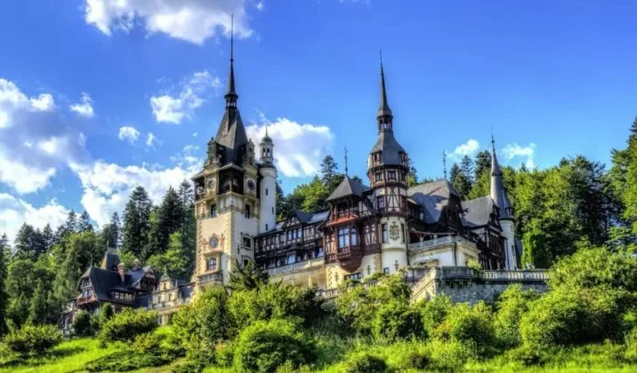 Castelul Peleș, un simbol al arhitecturii românești, înconjurat de natură verde.