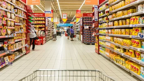 Rafturi cu produse alimentare într-un supermarket din România.