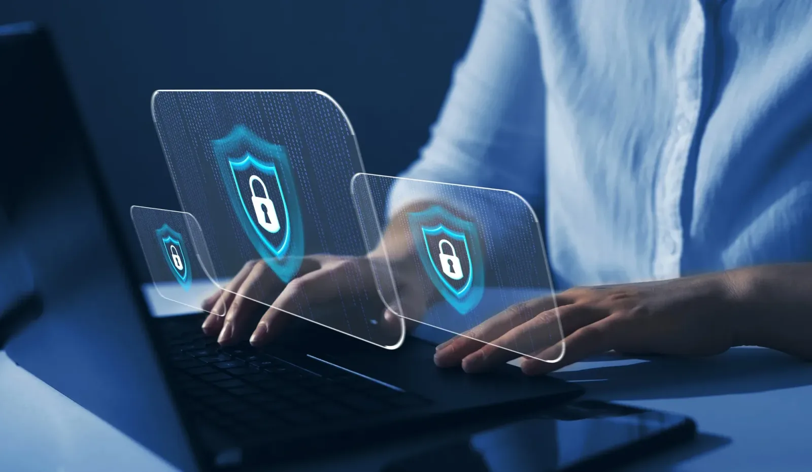 O persoană lucrează la un laptop cu simboluri de securitate.