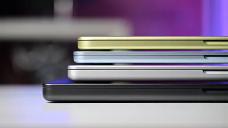 Patru modele de MacBook în diferite culori, așezate unul peste altul.