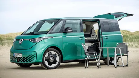 Volkswagen ID. Buzz pregătit pentru campare, cu ușa deschisă și mobilier exterior.