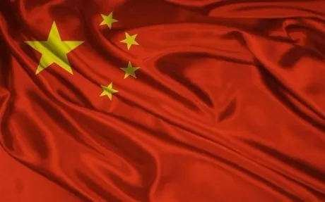 Steagul Chinei fluturând pe un fundal roșu vibrant.