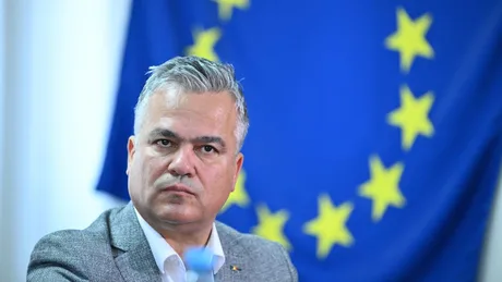 Adrian Veștea în fața steagului Uniunii Europene, discutând despre criza politică.