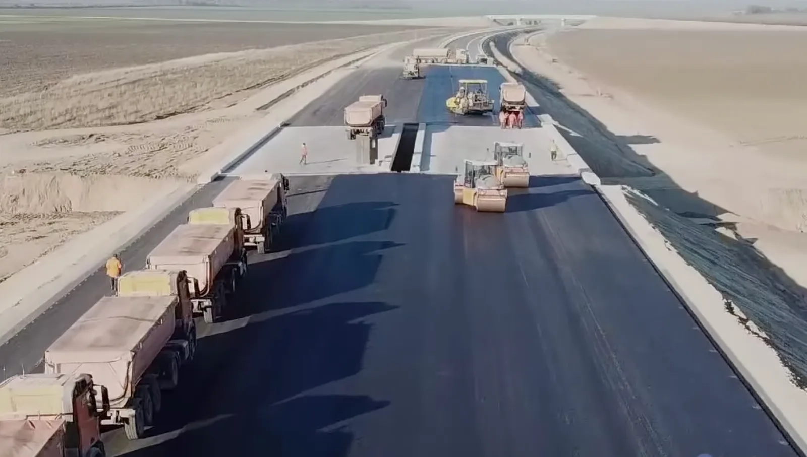 Lucrări pe autostrada A7, cu utilaje și camioane pe șantier.