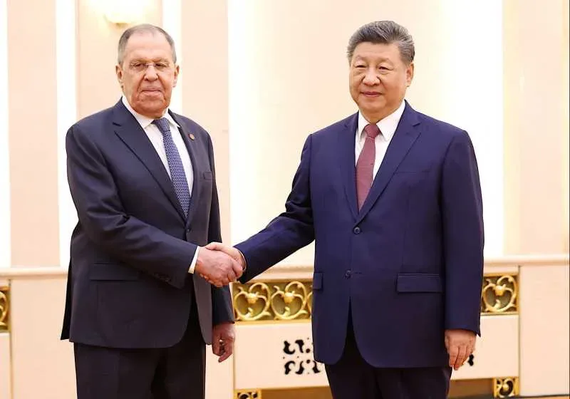 Xi Jinping și Serghei Lavrov strâng mâna la summitul BRICS.