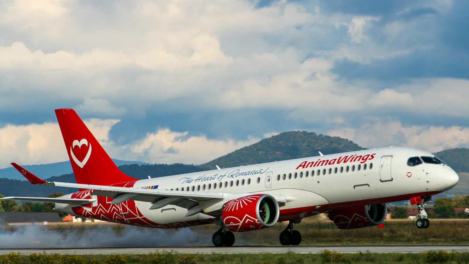 Avion AnimaWings decolând pe ruta București-Milano Malpensa, cu peisaj montan în fundal.
