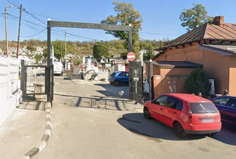 Intrarea în cimitirul Strehareți din Slatina, cu mașini parcate.