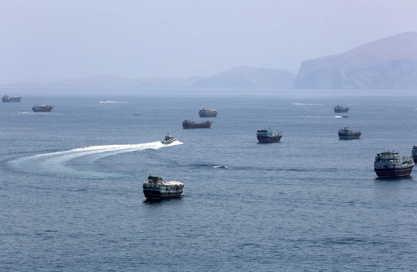 Flotă de petroliere navigând prin Strâmtoarea Ormuz în condiții de securitate sporită.