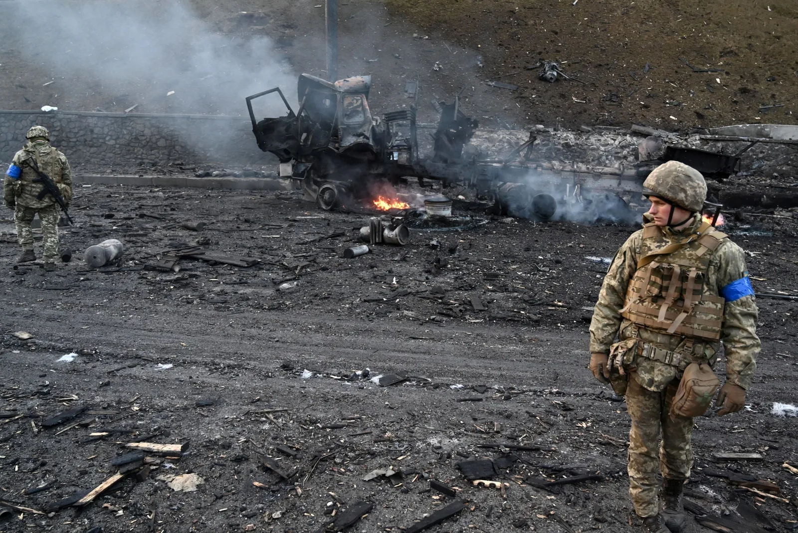Soldat ucrainean pe un teren afectat de conflict, în mijlocul distrugerii.