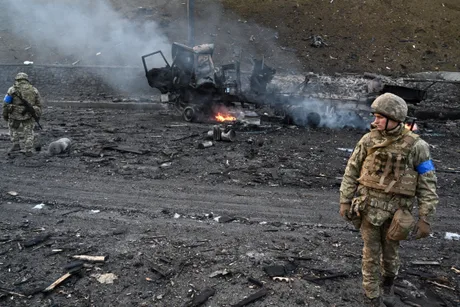Soldat ucrainean pe un teren afectat de conflict, în mijlocul distrugerii.