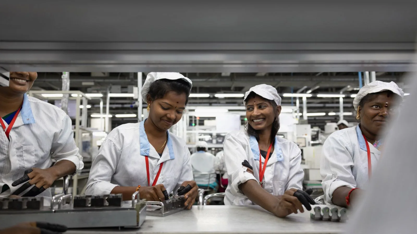 Angajați lucrând la asamblarea iPhone-urilor în India.