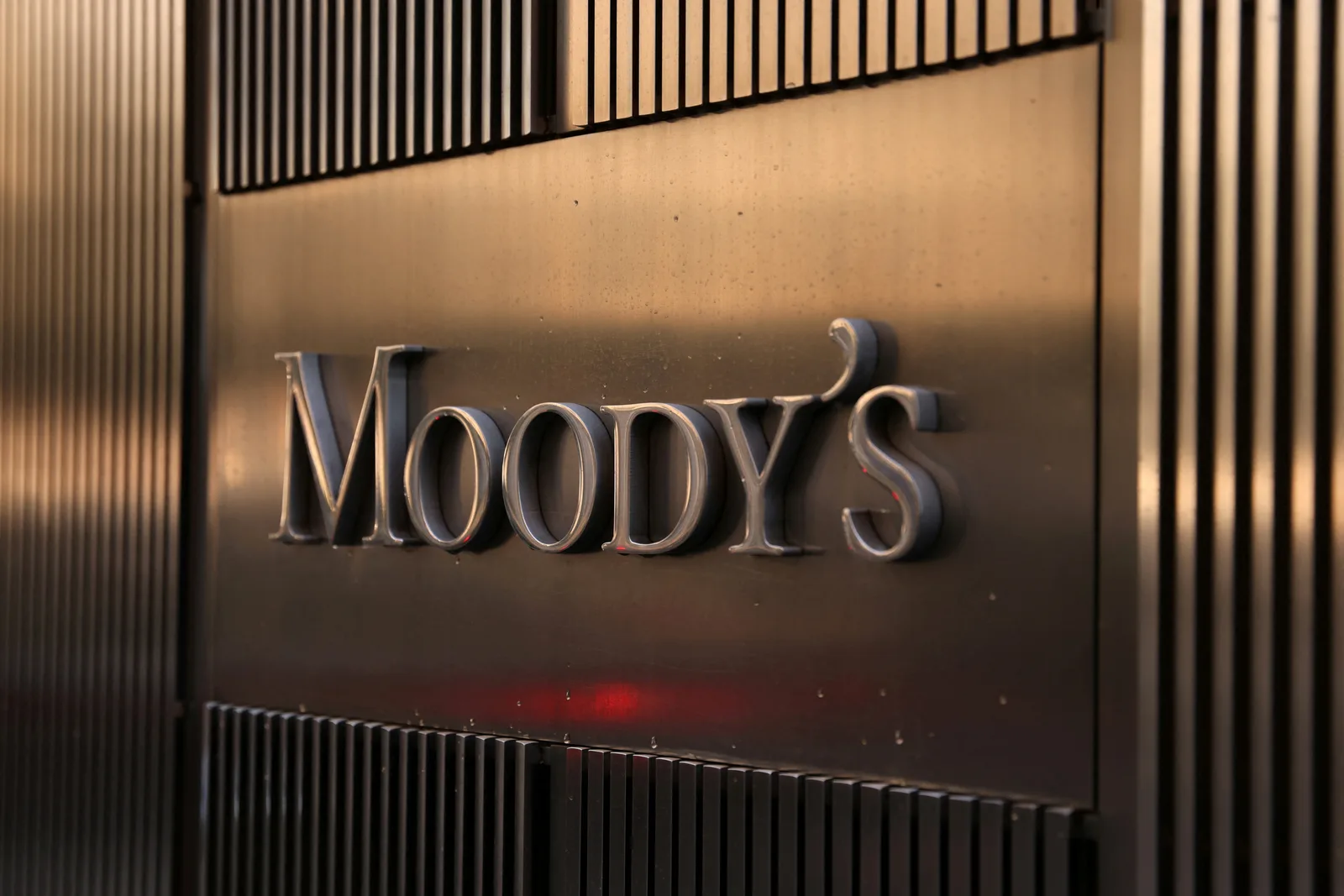 Logo-ul agenției de rating Moody’s pe un fundal metalic.