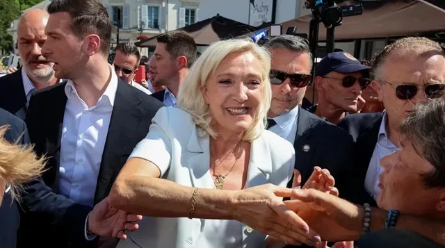Marine Le Pen salută susținătorii în timpul unui eveniment public.