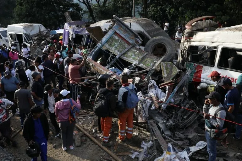 Oameni adunați în jurul vehiculelor distruse după explozia din Cajibio, Columbia.