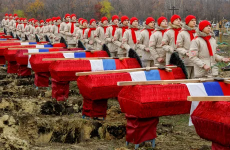 Soldați ruși în fața unor morminte, simbolizând pierderile din conflict.