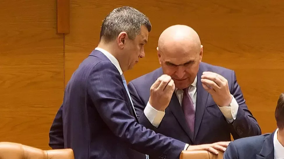 Ilie Bolojan discutând cu un coleg în Parlament.