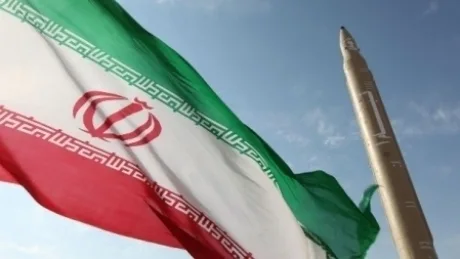 Steag iranian fluturând în fața unui rachete, simbol al tensiunilor regionale.