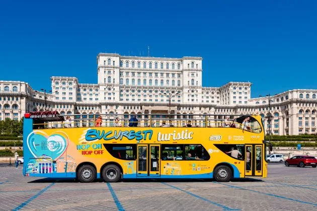Autobuz turistic în fața Palatului Parlamentului din București.
