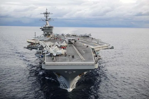 Portavionul USS Theodore Roosevelt navighează pe marea agitată, pregătindu-se pentru misiuni în Orientul Mijlociu.