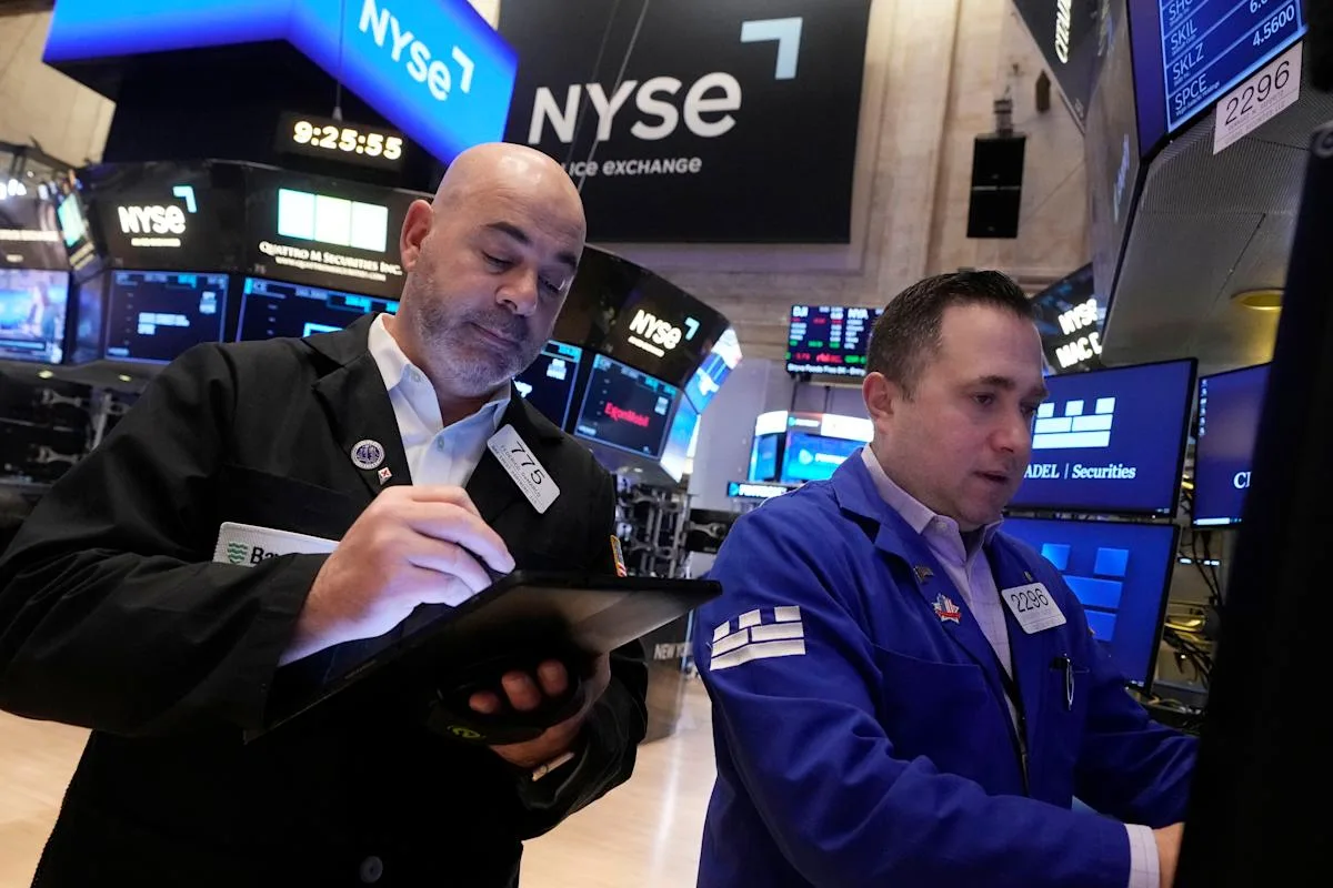 Doi bărbați discută despre piețele financiare la Bursa din New York.