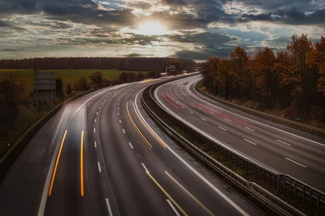 Peisaj de autostradă cu cer senin și vegetație în jur.