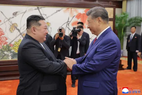 Xi Jinping și Kim Jong Un discutând despre cooperarea dintre China și Coreea de Nord.