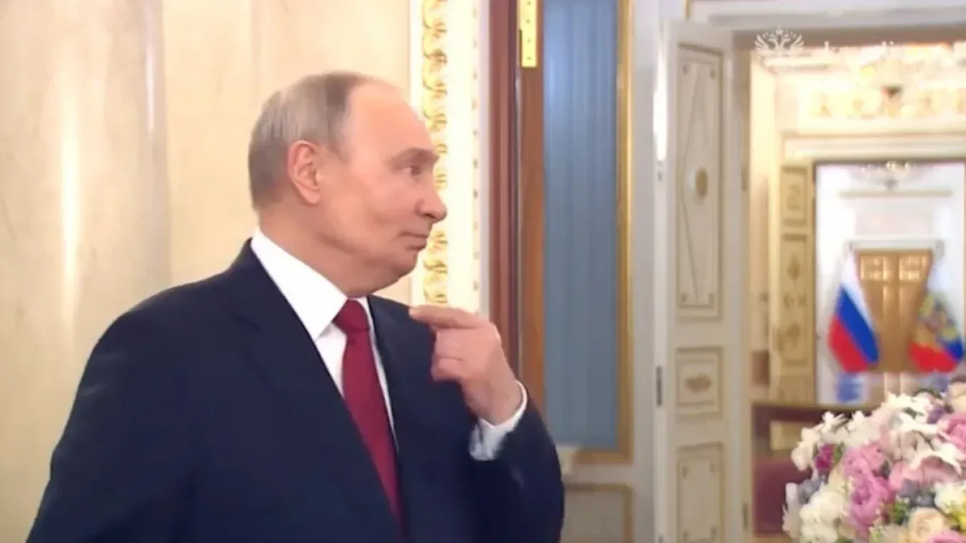 Vladimir Putin discutând la Kremlin, cu decor elegant în fundal.