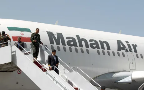 Aeronava Mahan Air cu pasageri coborând pe scări la aeroport.