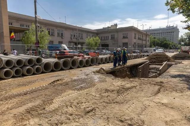 Lucrări de modernizare a canalizării pe Bulevardul Dinicu Golescu, cu utilaje și muncitori la fața locului.