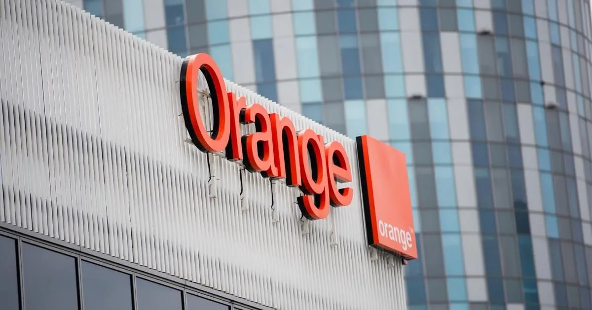 Logo-ul Orange pe un clădire modernă, simbolizând telecomunicațiile.
