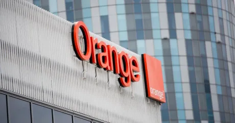 Logo-ul Orange pe un clădire modernă, simbolizând telecomunicațiile.