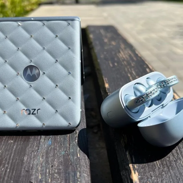 Un telefon pliabil cu cristale Swarovski pe un fundal de lemn.