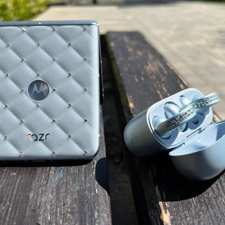 Un telefon pliabil cu cristale Swarovski pe un fundal de lemn.