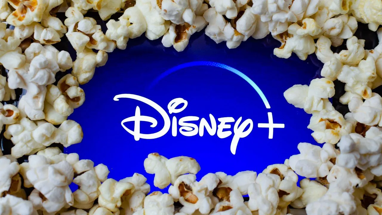 Logo Disney+ înconjurat de floricele de porumb, simbolizând divertismentul.