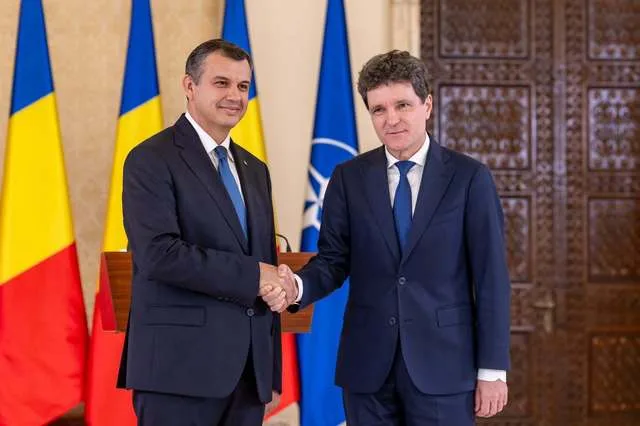 Eugen Tomac și Nicușor Dan la o întâlnire oficială, cu steaguri românești în fundal.