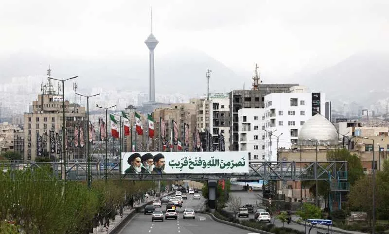 Peisaj urban din Teheran cu steaguri și clădiri moderne.