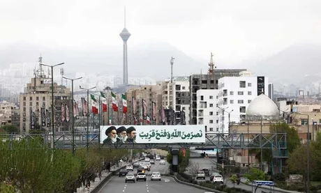 Peisaj urban din Teheran cu steaguri și clădiri moderne.