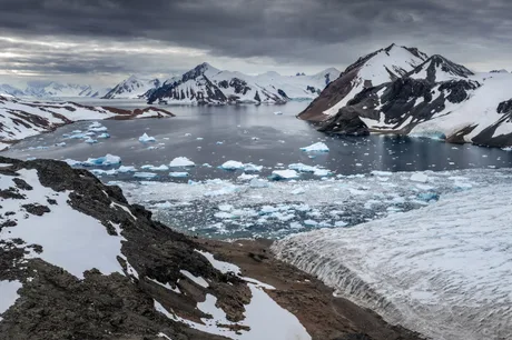 Peisaj antarctic cu ghețuri și munți, evidențiind efectele schimbărilor climatice.