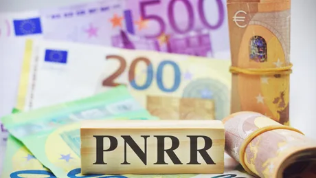 Bancnote euro și un bloc de lemn cu inscripția PNRR.