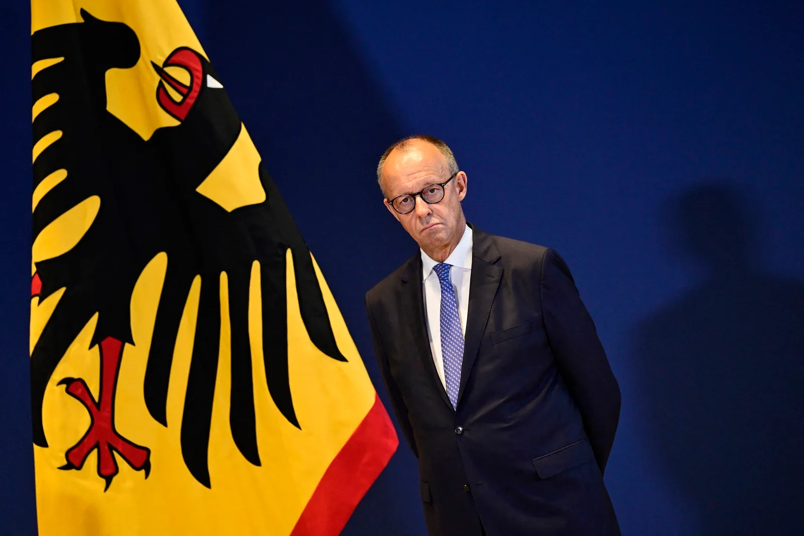 Friedrich Merz, lider CDU, în fața steagului Germaniei, reflectând la provocările politice.