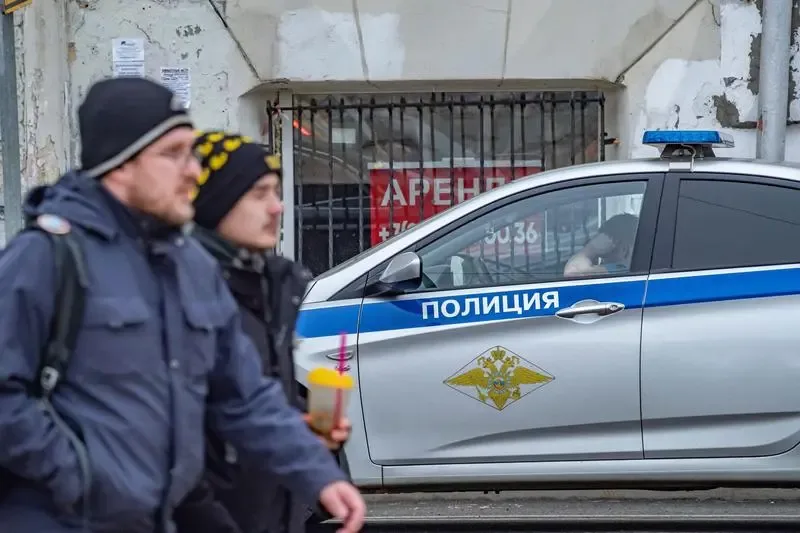 Bărbați pe stradă, în apropierea unei mașini de poliție din Penza.