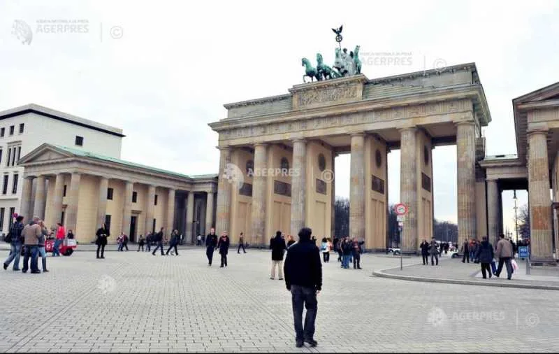 Oameni care se plimbă în fața unei clădiri istorice din Berlin.