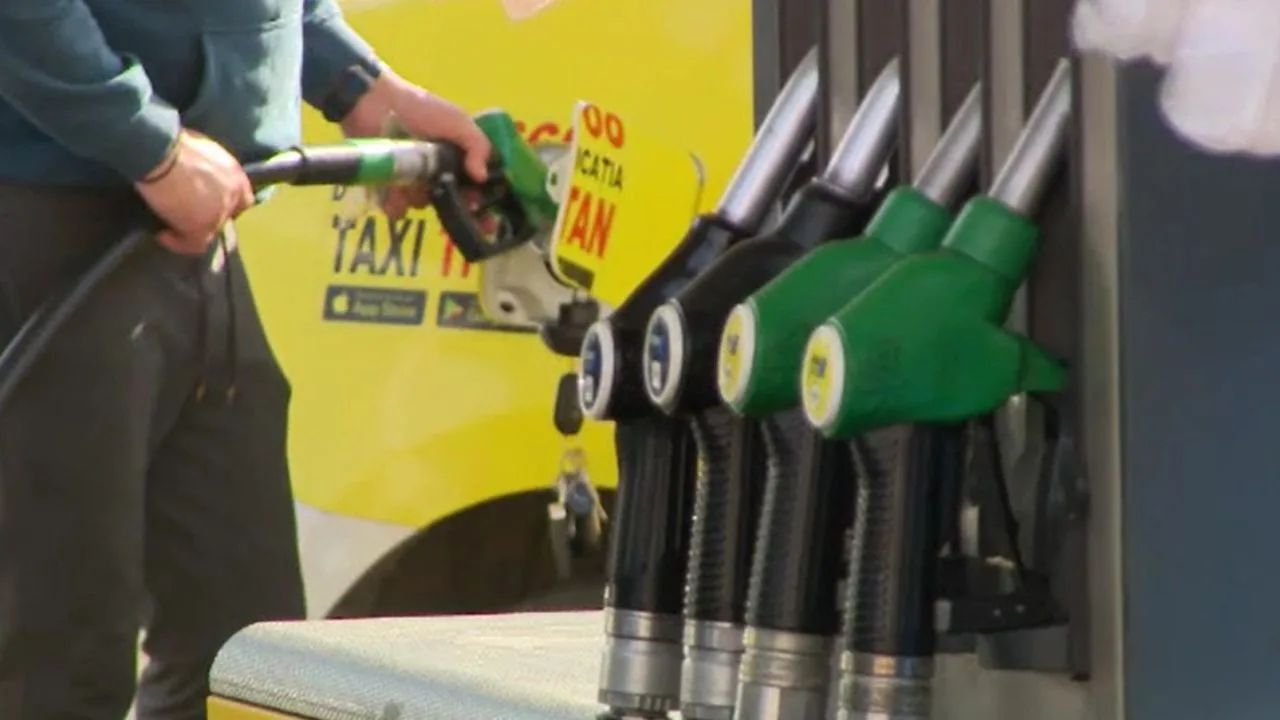 Șoferi alimentând la o stație de carburant, prețuri fluctuante la pompă.