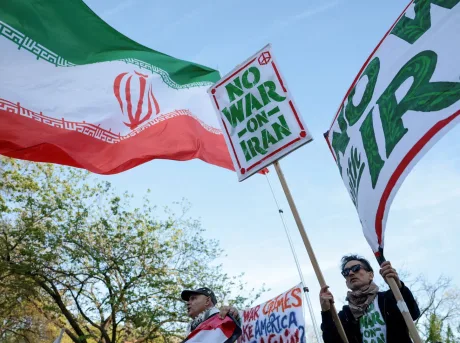 Proteste împotriva războiului în Iran, cu steaguri și pancarte.