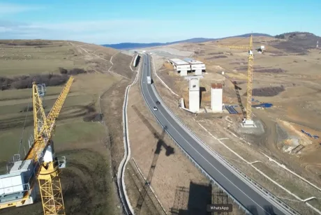 Peisaj de șantier cu utilaje și drum pe Autostrada Sibiu-Pitești.