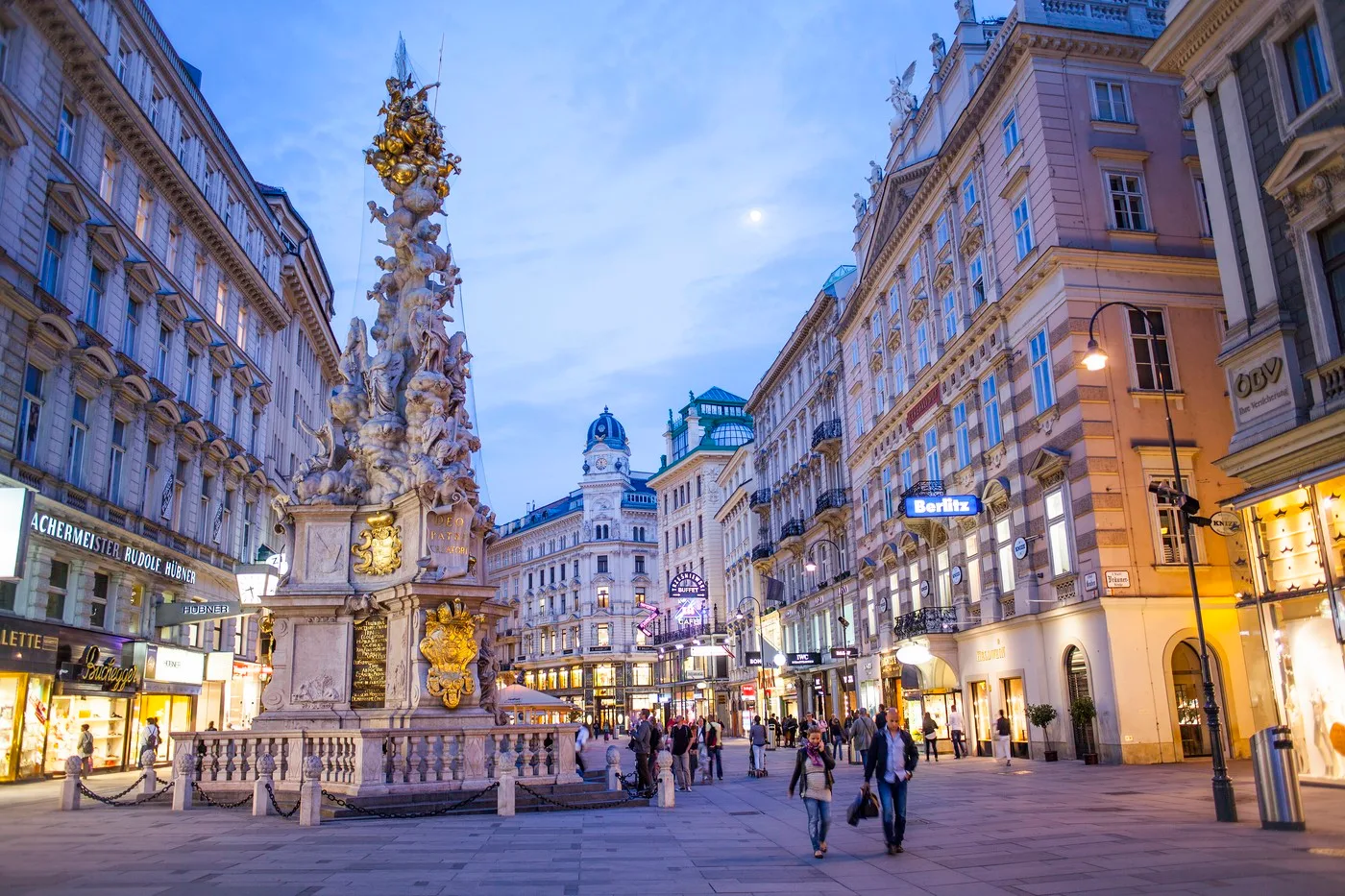 Stradă din Viena, plină de oameni și clădiri istorice, la apus.