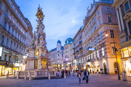 Stradă din Viena, plină de oameni și clădiri istorice, la apus.