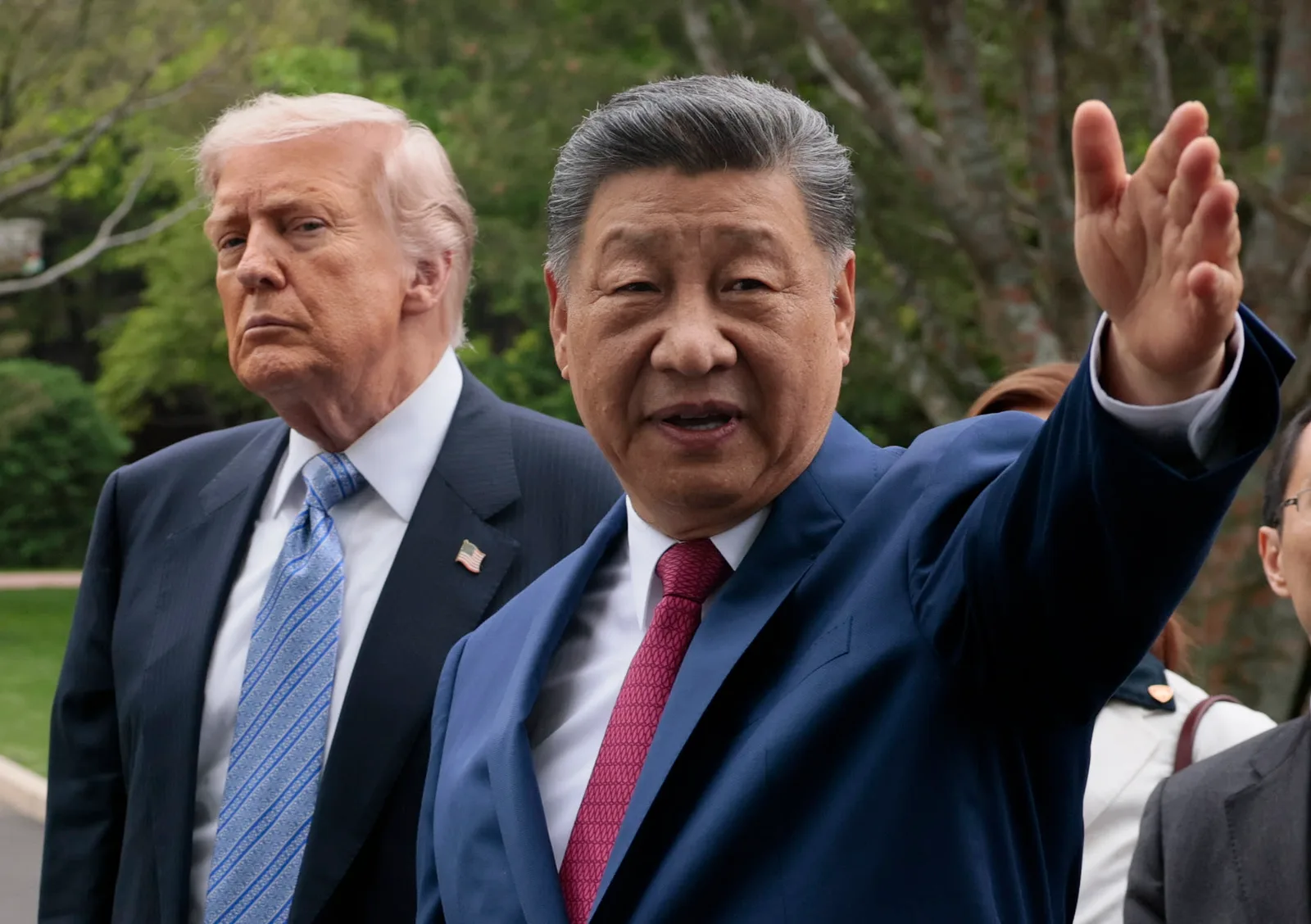 Donald Trump și Xi Jinping discutând în aer liber, cu expresii serioase.
