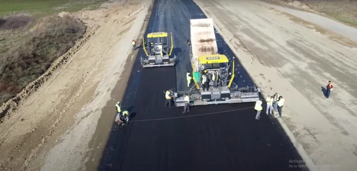 Lucrări de asfaltare pe un tronson de drum în construcție.